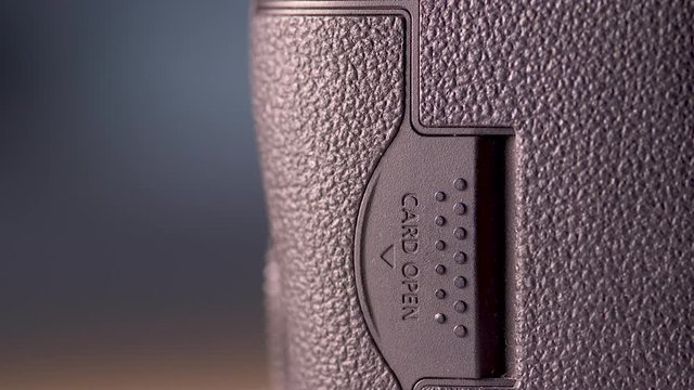 Close up of the  SD Card cover of a DSLR Camera being closed.
