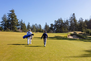 Golfer and Caddie walking up to the green