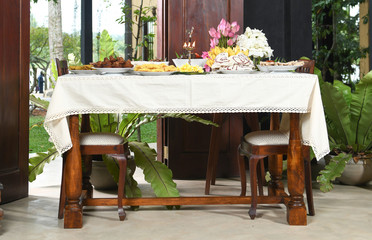 Sinhala Tamil New Year Traditional Foods with Oil lamp, Sri Lanka, items like Murukku, Kokis, Kewum, Aluwa, and Aasmi.