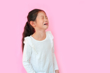 Obraz premium Portrait asian little child girl crying isolated on pink background with copy space. Kid with sad expressions.