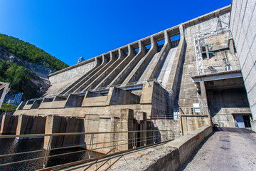 Industrial photography. The main building with turbines of the Zeya hydroelectric station on the background of a concrete dam.