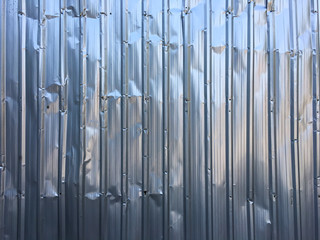 Crumpled Corrugated metal texture or Galvanized iron steel background, shiny fence, Silver Colour