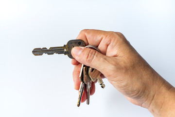 Woman's right hand use keys for lock or unlock in white background, Close up & Macro shot, Selective focus, Security concept