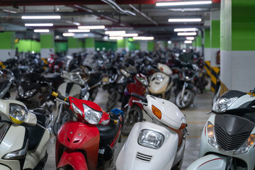 Motorcycles and scooters park in the underground basement parking of the apartment