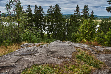 Fototapeta premium The nature of Karelia.Typical Karelian landscape in the vicinity of Sortavala: a forest of conifers, traces of volcanic lava, rocks and volcanic rocks. Russia, Karelia, Sortavala.