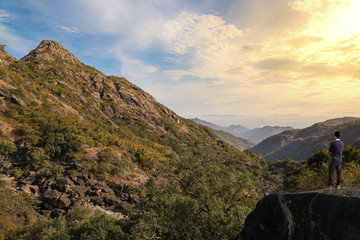 Fototapeta na wymiar Male tourist enjoy sunrise view at Mount Abu Rajasthan India with scenic mountain landscape