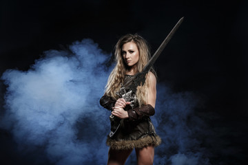 Beautiful female viking woman warrior in battle with big two-handed sword. Ancient times. Amazon...