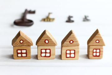 wooden houses with windows and a roof on a background of silhouettes of keys of different sizes. real estate offer