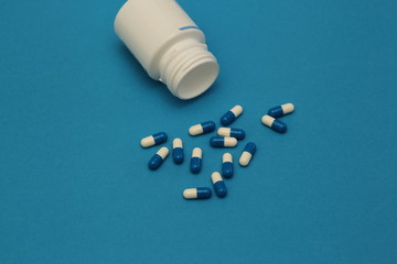 pills and bottle on blue background