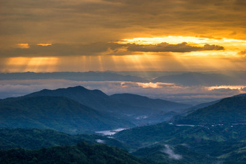 abstract background blur view of the sun shining through the clouds,surrounded by large mountains and various species of trees