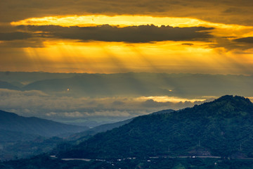 Obraz premium abstract background blur view of the sun shining through the clouds,surrounded by large mountains and various species of trees