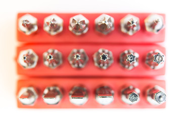 Set of screwdriver bits in a red holder on a white background top view