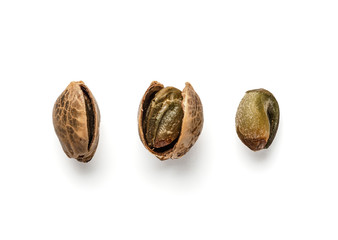 Creative layout of hemp seeds. Superfood hemp concept. Top view of three cannabis or hemp seeds in shell, open shell and unshelled seed kernel. Isolated on white with clipping path.