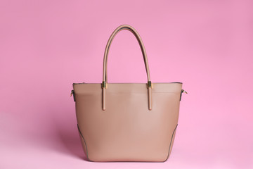 Stylish woman's bag on light pink background