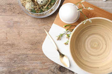 Rustic Easter table setting with eggs and floral decor, flat lay. Space for text