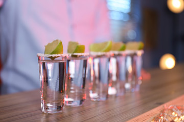 Mexican Tequila shots with salt and lime slices on bar counter