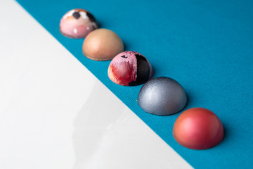 Colorful modern chocolate bonbon truffles on blue and marble