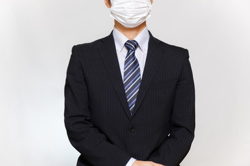 マスクをつけたスーツ姿の男性　感染症対策　エチケット