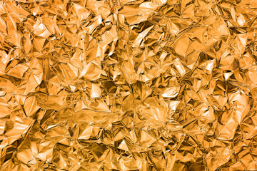 Shiny crumpled metal foil as gold background or texture