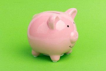Piggy bank on green background, space for text. Finance, saving money