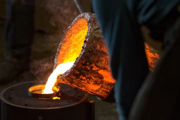 Fotobehang Molten bronze poured into mold by melter in foundry workshop © LouisFerdinand