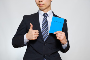 年金手帳を持つスーツ姿の男性　厚生年金　前向き