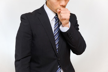 咳をするスーツ姿の男性