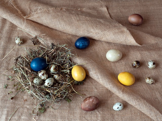 Colored Easter eggs, quail eggs on a rough cloth background