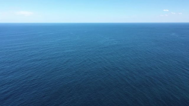 Clear blue ocean stretching off into distane with blue sky vast expanse of water