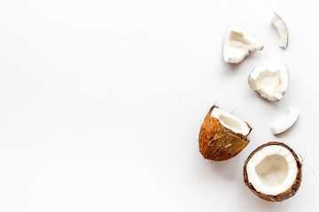 Coconuts frame - halfs and scattered pieces - on white background top-down copy space