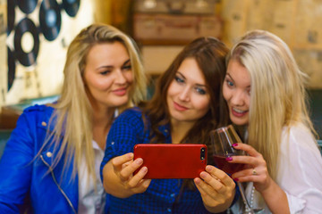 Girls in pub club taking self photo with phone