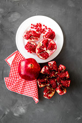 Cut pomegranate with ripe seeds on grey background top-down