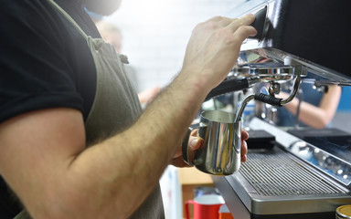 Bartender prepare coffee on a coffee machine and whips milk with steam, hands closeup. Small business concept