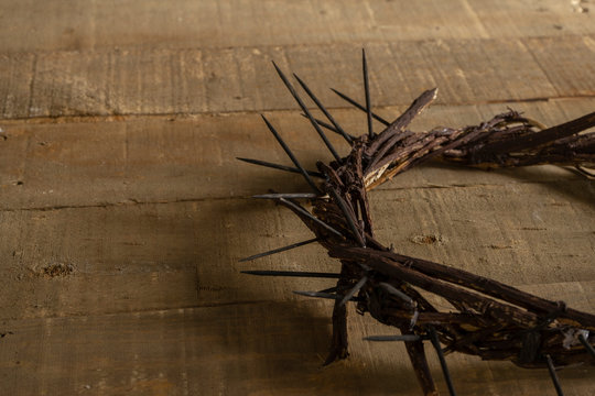 Crown of thorns on wooden background with copy space. Easter religious motive commemorating the resurrection of Jesus.