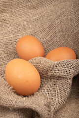 Chicken eggs on a background of rough homespun fabric. Country food. Close up.