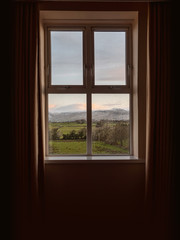 Window in a house with beautiful view on a mountains. Concept high end accommodation.