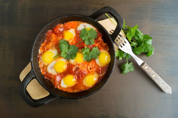 Shakshuka in the pan. Omelet with tomatoes, pepper, vegetables and herbs.