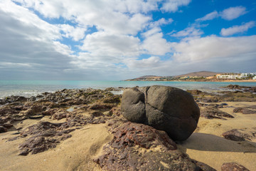 Big stone on a sandy beach near the sea