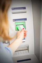 Woman using modern ATM nashine - cash withdrawal.