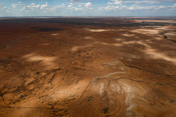 Kati Thanda-Lake Eyre Salt Flats outback South Australia aerial photography with little salt during the summer, dramatic clouds casting shadows on the brown baron lake, Australia