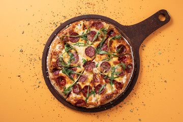 salami pizza in yellow top view