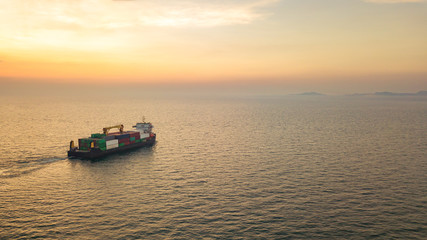 Aerial view from drone, a cargo vessel with peaceful sea in beautiful scenic sky. Professional business logistics and transportation of cargo ship.