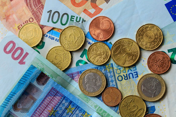 Background from euro banknotes and euro cents. World of money