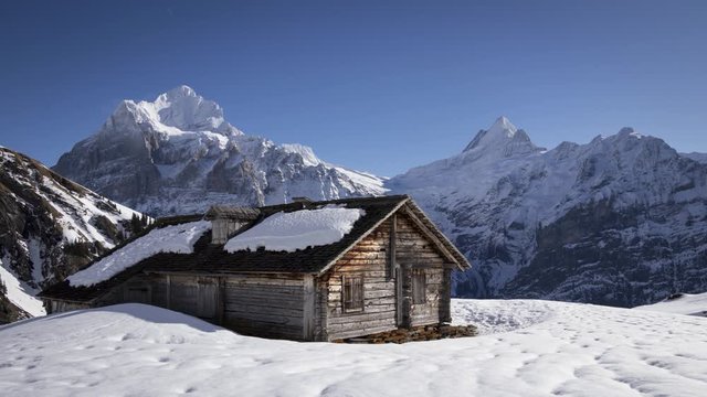 Isolated Wooden Cabin on Snow Covered Swiss Mountain Peak