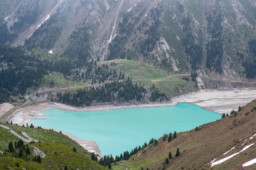 Beautiful landscape of blue lake in the mountains. Big Almaty Lake in the spring.
