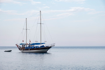 Old sailing boat is standing anchored  near the coast.