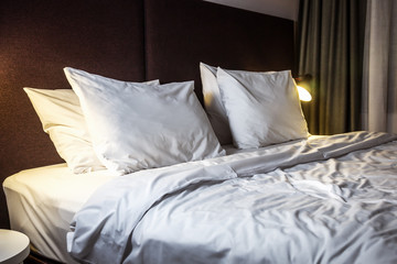 large bed with pillows in the hotel or at home. Concept on preparation of the bed in a hotel room or at home