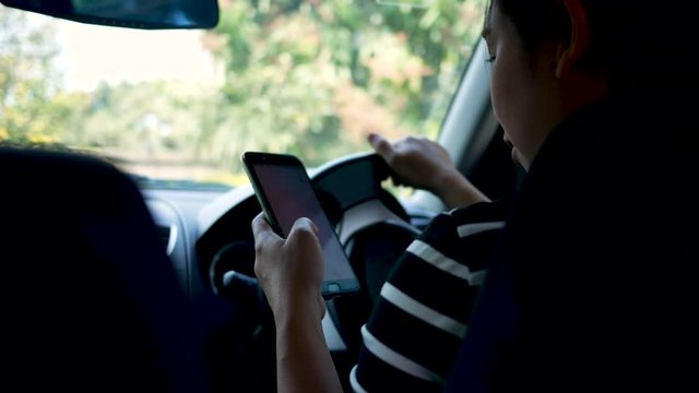 Asian young woman using the Google Maps application on a smartphone to search for directions while driving. Concept of using technology in transportation.
