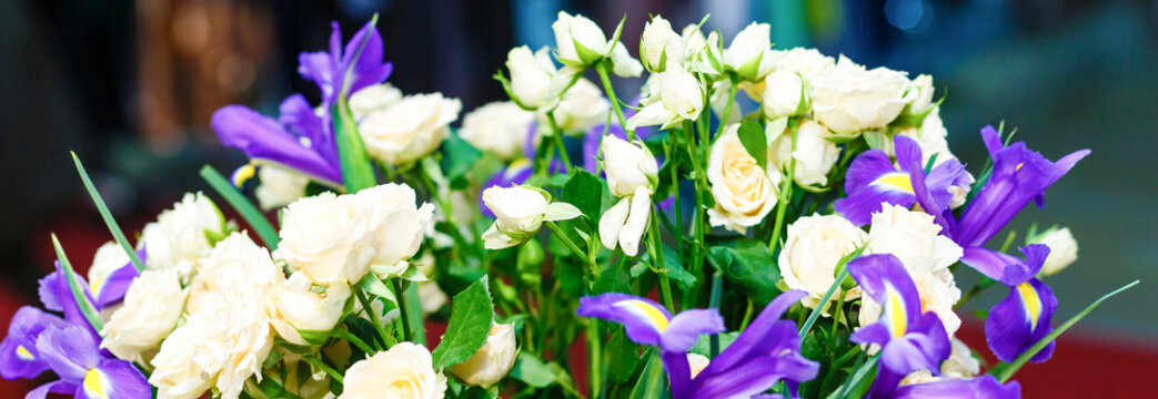 Beautiful wedding bouquet of blue irises and white roses in a vase