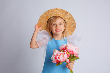 baby girl with a bouquet of flowers and a straw hat on a white background